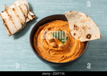 Hummus di zucca in ciotola su sfondo blu Foto Stock