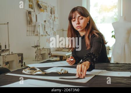 Seamstress che traccia il disegno sul tessuto Foto Stock