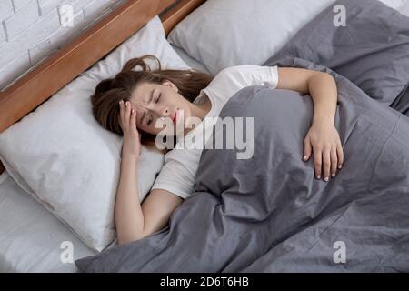 Disturbi della salute mentale. Vista dall'alto di una donna infelice sdraiata a letto, affetta da depressione, ansia o insonnia Foto Stock