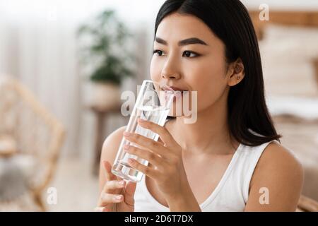 Giovane attraente donna asiatica bere acqua, copia psace Foto Stock