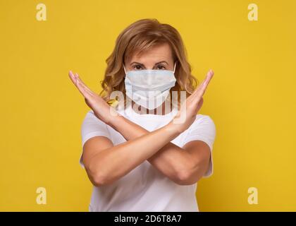 donna che indossa la protezione del viso in prevenzione per il coronavirus mostrando gesto Arrestare l'infezione Foto Stock