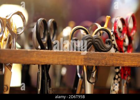 Clip per capelli a forma di baffi su un supporto per forbici barbiere e. spazio vuoto per il testo Foto Stock