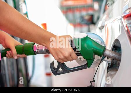 Rifornimento della vettura con benzina. Mani della donna che versano benzina o gas nel serbatoio della sua auto presso la stazione di rifornimento Foto Stock