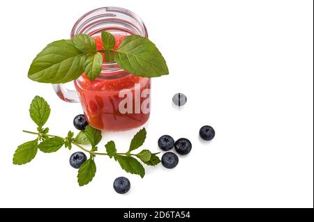 Cocktail di cocomero in un vasetto con foglie di menta, mirtilli e una cannuccia da cocktail su uno sfondo bianco isolato. Spazio per la copia. Spazio per la copia. Foto Stock