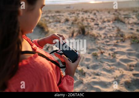 Giovane uomo afro-americano di stile con mano in Pocket surf internet sul cellulare mentre camminando sul sentiero in città Foto Stock