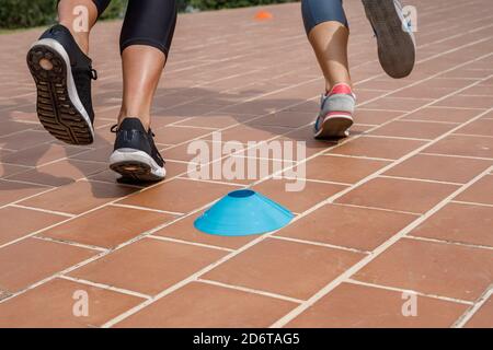 Gambe di atlete FIT che corrono lungo la strada e competono durante l'allenamento attivo in estate Foto Stock