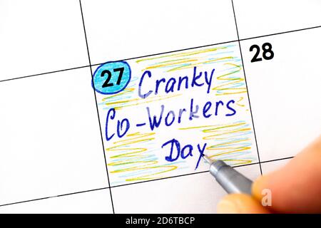 Donne dita con penna di scrittura promemoria Cranky Co-lavoratori giorno in calendario. Ottobre 27 Foto Stock