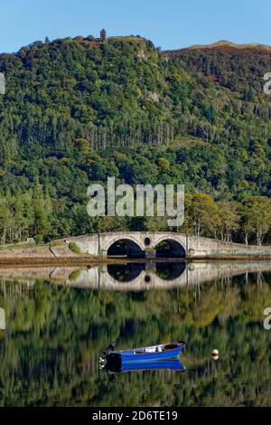 La barca blu da pesca si riflette nelle acque calme di Loch Fyne a Inverary un posto incantevole e tranquillo in Argyll e. Bute nel Nord Ovest della Scozia Foto Stock