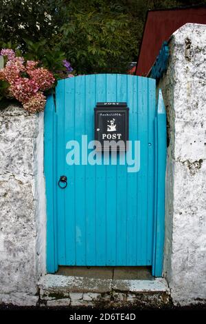 Incantevole cancello del giardino turchese/blu dipinto con colori vivaci nelle strade secondarie Di Tobermory sull'isola di Mull nell'interno Ebridi Foto Stock