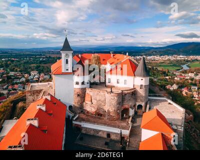 Vista aerea del castello medievale sulla montagna nella piccola città europea nella stagione autunnale. Palanok castello, Mukachevo, Ucraina Foto Stock