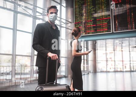 Uomo che indossa una maschera in attesa del suo treno Foto Stock