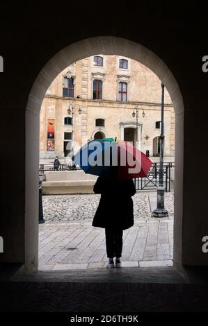 tourist, con un ombrello colorato a Matera, rifugi sotto l'arco durante la pioggia 2020 ottobre Foto Stock