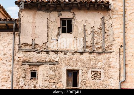 Esterno di un vecchio edificio abbandonato con muri in pietra sminuzzanti e. Piccole finestre situate sulla strada della città medievale Cuenca in Spagna Foto Stock