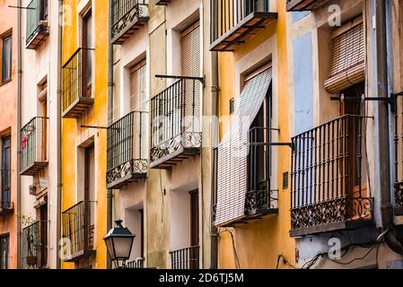 Basso angolo di vecchio edificio di appartamenti con facciata colorata dipinta E piccoli balconi con ringhiere in metallo sulla strada di Cuenca Città in Spagna Foto Stock