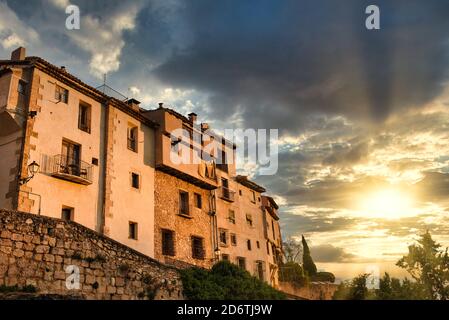 Da sotto la facciata di un vecchio edificio residenziale in pietra intemperie Sulla strada di Cuenca città in Spagna contro cielo nuvoloso al tramonto Foto Stock