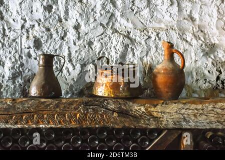 Varie vecchie caraffe, piatti di enologo su una mensola in legno nella cantina Foto Stock