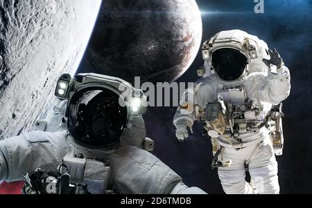 Astronauti nello spazio esterno sullo sfondo di pianeti abitati Foto Stock