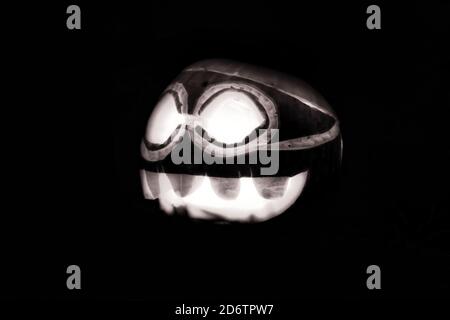 Zucca di Halloween brillante nella notte buia in bianco e nero. Foto Stock
