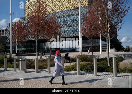 Dato che il numero di casi di Covid-19 a Birmingham è aumentato drasticamente nelle ultime settimane, sono state annunciate misure di blocco più estese per Birmingham e per altre zone delle West Midlands, La gente gode del sole in Centenary Square davanti alla Biblioteca di Birmingham mentre il centro della città è ancora molto tranquillo il 29 settembre 2020 a Birmingham, Regno Unito. Con l'applicazione della regola dei sei, l'area di Birmingham è stata ora scalata a un'area di intervento nazionale, con il divieto di socializzare con persone al di fuori della propria famiglia, a meno che non provengano dallo stesso sostegno Foto Stock