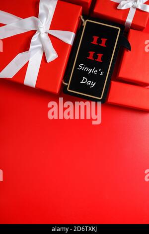 Shopping online della Cina, 11.11 single's giorno di vendita concetto. Le scatole regalo rosse su sfondo rosso con spazio di copia per il testo 11.11 vendita giorno del singolo. Foto Stock