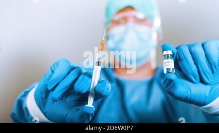 COVID-19 vaccino del Coronavirus. Scienziato virologo con siringa e flaconcino pronti per l'iniezione. Foto Stock