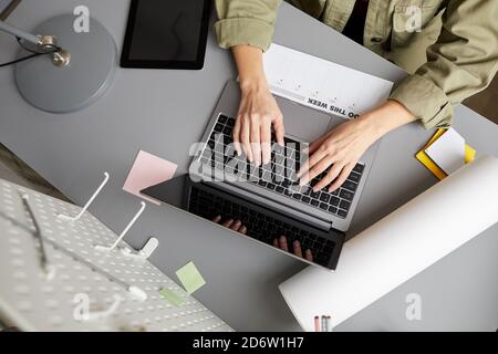 Primo piano di una giovane donna moderna che usa il computer portatile mentre si siede alla scrivania, spazio per la copia Foto Stock