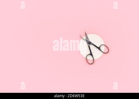 Forbici piatte per la visualizzazione dall'alto per manicure su sfondo rosa Foto Stock