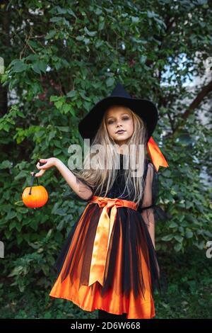 Ragazza bambino divertente in costume di strega per Halloween con zucca Jack esterno Foto Stock