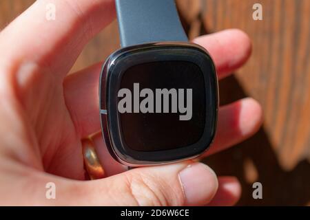 Quadrante dell'orologio che tiene la mano umana sul dispositivo indossabile dell'orologio intelligente Fitbit Sense, San Ramon, California, 22 settembre 2020. () Foto Stock