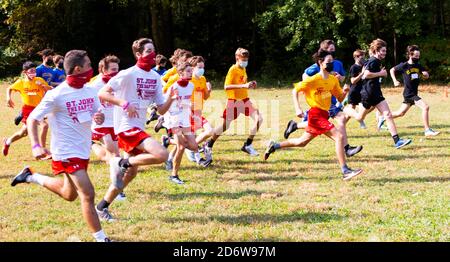 Syosset, New York, USA - 10 ottobre 2020: L'inizio di una corsa di fondo dei ragazzi Freshmen durante la pandemia del coronavirus con corridori che indossano maschere. Foto Stock