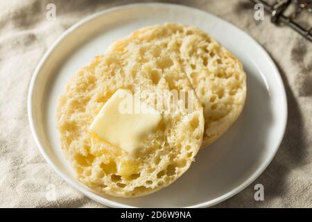 Muffin inglesi tostati fatti in casa con una linguetta di burro Foto Stock