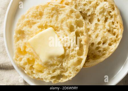 Muffin inglesi tostati fatti in casa con una linguetta di burro Foto Stock