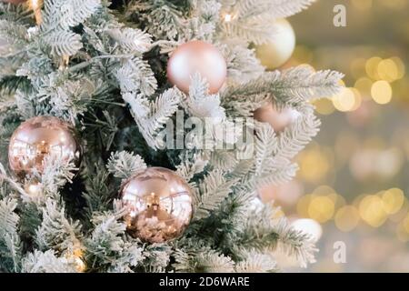Albero di natale decorato in oro con palline e luci su sfondo sfocato. Buon Natale card. Decorazione di Capodanno su sfondo bokeh. Spazio di copia. Foto Stock