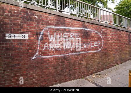 Graffiti dipinti di bianco su muro di mattoni rossi Foto Stock