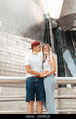 Coppia che visita l'esterno del museo Guggenheim a Bilbao, Spagna Foto Stock