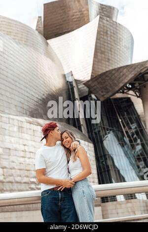 Coppia che visita l'esterno del museo Guggenheim a Bilbao, Spagna Foto Stock