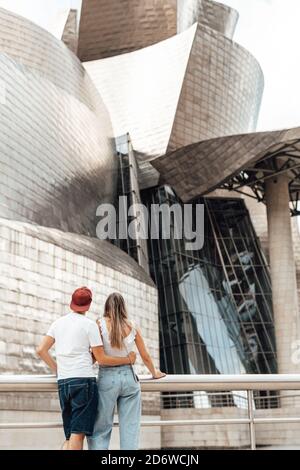 Coppia che visita l'esterno del museo Guggenheim a Bilbao, Spagna Foto Stock