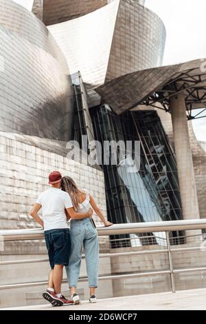 Coppia che visita l'esterno del museo Guggenheim a Bilbao, Spagna Foto Stock