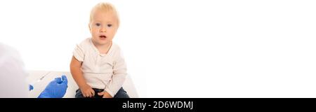 Scatto panoramico del pediatra che tiene la siringa vicino al bambino isolato su bianco Foto Stock