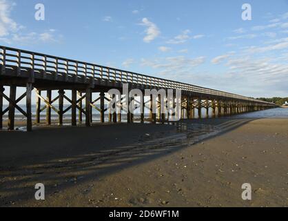 Vista prospettica del ponte in polvere di legno che si estende sopra la baia. Foto Stock