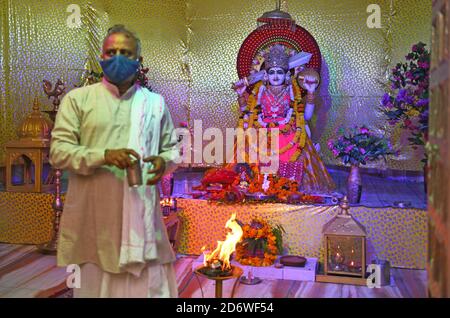 Beawar, Rajasthan, India, 19 ottobre 2020: Sacerdote indù esegue 'aarti' della Dea Durga durante il festival Navratri in corso in mezzo alla pandemia di Coronavirus, al tempio di Ashapura Mata a Beawar. Sharad Navratri è celebrato nel mese santo di Ashwin. Il festival Durga Puja di nove giorni, che commemora l'uccisione del re demone Mahishasur da parte della dea Durga, segna il trionfo del bene sul male. I devoti digiunano durante il periodo e visitano i templi. Credit: Sumit Saraswat/Alamy Live News Foto Stock