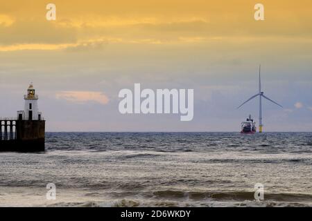 Supporto nave Assister in piedi da turbine eoliche per l'aiuto in Il mare del Nord fuori Blyth all'alba Foto Stock