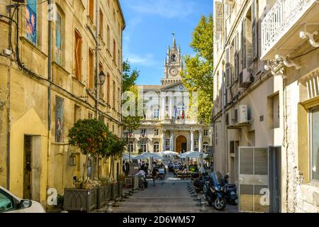 La piazza principale e il municipio di Avignone in estate giornata con un grande caffè con posti a sedere all'aperto e ombrelloni Pieno di turisti in Avignone Francia Foto Stock