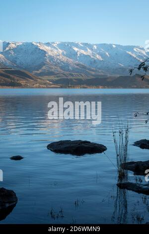 Montagne innevate sulla catena montuosa di Pisa, che si affaccia sul lago Dunstan, Cromwell, Central Otago, South Island, Nuova Zelanda Foto Stock