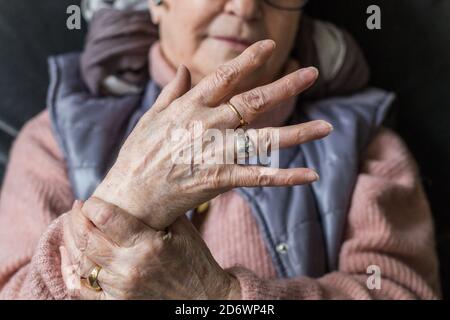 Senior donna che soffre di un dolore articolare in mano. Foto Stock