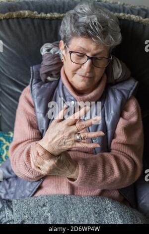 Senior donna che soffre di un dolore articolare in mano. Foto Stock