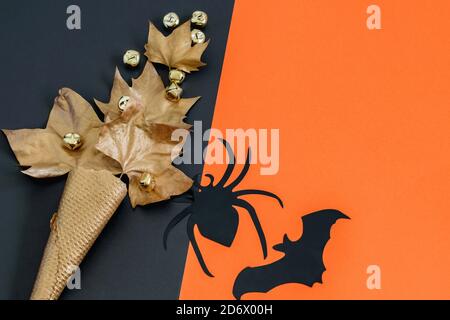 Ragno e pipistrello decorativi neri, cono gelato con cialde dorate con foglie sullo sfondo nero-arancione. Biglietto d'auguri Halloween, bel design festivo Foto Stock