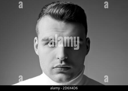 Uomo primo piano viso con capelli lucidi. Concetto di barbiere. Bel ragazzo. Mascolinità e bellezza. Uomo ben curato aspetto elegante. Acconciatura Foto Stock