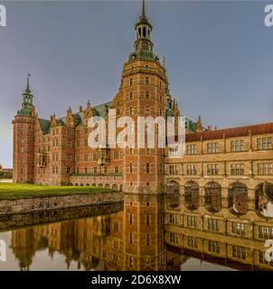 Castello di Frederiksborg nella prima luce del mattino, riflettendo nel fossato da un'angolazione insolita, Hillerod, Danimarca, 17 ottobre 2020 Foto Stock