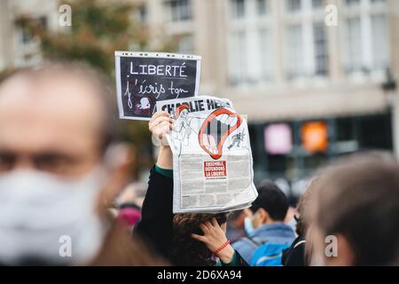 Strasburgo, Francia - Ott19, 2020: Donna con il giornale Charlie Hebdo in Place Kleber per rendere omaggio all'insegnante di storia Samuel Paty, decapitato il 16 ottobre dopo aver mostrato le caricature del profeta Muhammad in classe Foto Stock